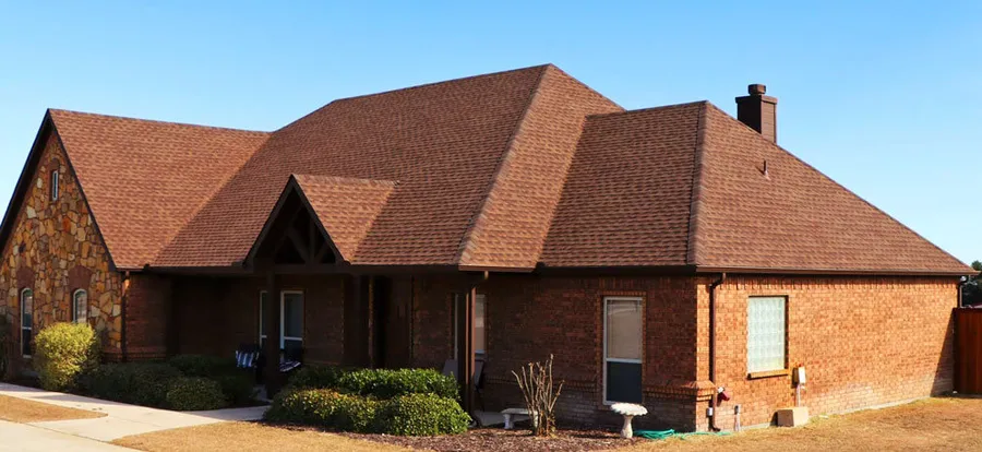 A brick and stone ranch with a new brown architectural shingle roof