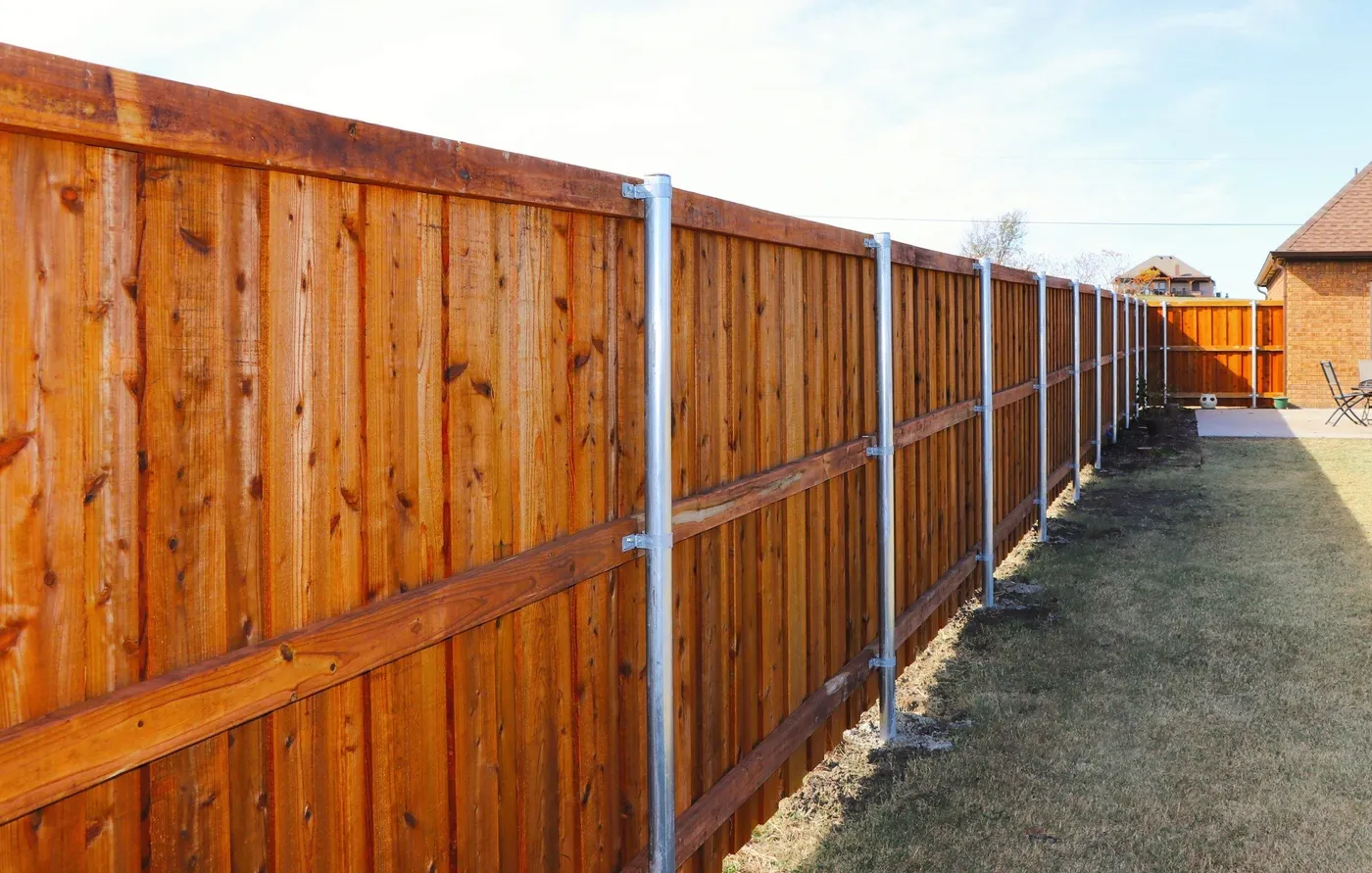 A long stained cedar privacy fence on steel posts