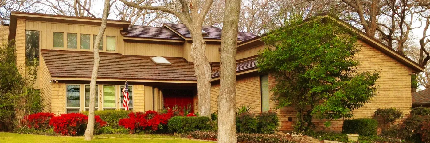 A two-story home with a brown stone-coated steel shake roof
